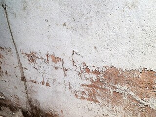 Weathered brown concrete wall with a rough, grungy texture and peeling paint