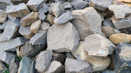 Rough natural river stones in various sizes and colors piled together for construction use