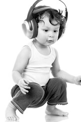 Cute toddler listening to music with wireless headphones and singing along