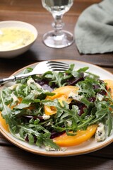 Tasty salad with arugula, blue cheese and vegetables on wooden table, closeup