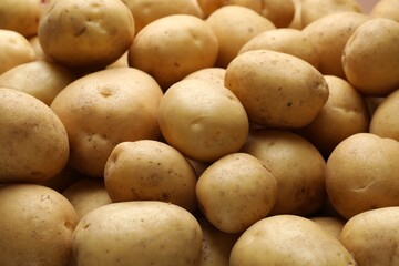Fresh raw potatoes as background, closeup view