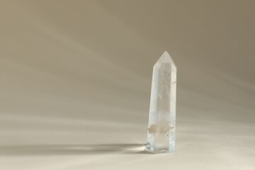 Aura. Beautiful crystal on beige background. Space for text