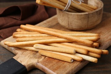 Delicious grissini sticks on wooden table, closeup
