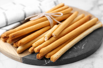 Delicious grissini sticks on light table, closeup