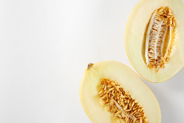 Halves of ripe melon on white background, flat lay. Space for text