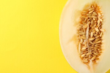 Half of ripe melon on yellow background, top view. Space for text