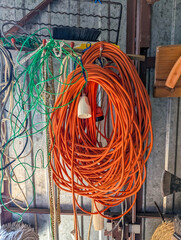 Bright orange electrical extension cord wound in perfect coil displayed in workshop construction...