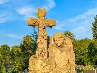 Warsaw, Poland, June 16, 2025 Stone cross monument with carved figures stands majestically against...