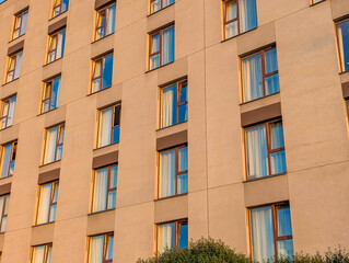 Fototapeta premium Corner perspective of contemporary orange brick apartment building showcasing modern residential architecture design