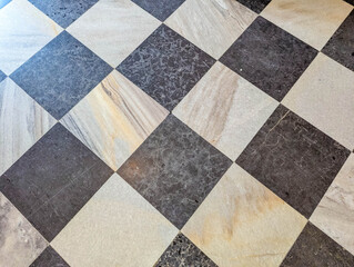 Geometric diamond pattern flooring featuring alternating dark and light marble tiles in classic checkerboard arrangement