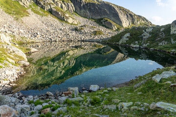 See-through reflection of Aiguilles Rouges mountain range on the Lac de la Remuaz in the French Alps.