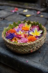 Balinese Offering Basket with Colorful Flowers on Stone Surface