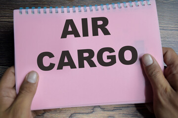 Concept of Air cargo transportation cargo via aircraft write on book isolated on Wooden Table.