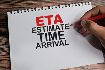 Concept of ETA - Estimate Time of Arrival write on book isolated on Wooden Table.