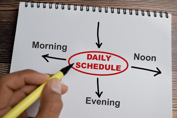 Concept of Daily schedule write on book with keywords isolated on Wooden Table.