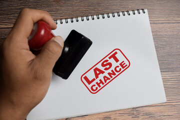 Red Handle Rubber Stamper and Last chance text above book isolated on wooden background