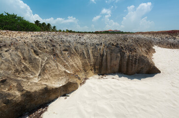 Varadero,Cuba, gorgeous inviting view on white sand majestic beach with old, naturally formatted volcanic cliff near the ocean shore 