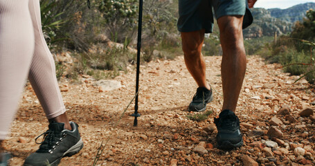 People, legs and hiking with stick on mountain trail for fitness, outdoor exercise or adventure....