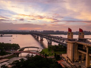 Obraz premium Nanjing skyline glowing under a warm sunset with rivers reflecting evening colors in a vibrant urban environment
