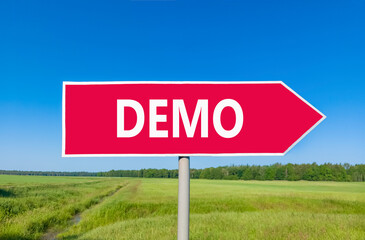 Demo symbol. Concept word Demo on beautiful red road sign. Beautiful blue sky green grass and...