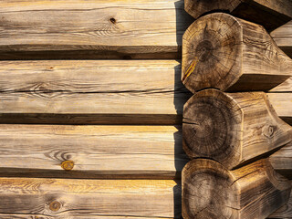 A wooden wall with a wooden frame. The wood is weathered and has a rustic appearance. The frame is made of wood and is placed on the wall. Scene is warm and inviting. Old craft and skill.