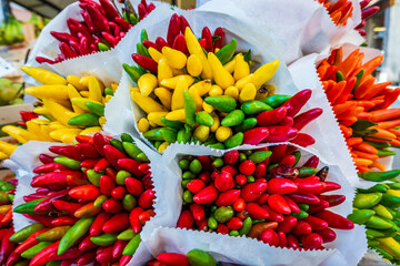 Colorful display of fresh chili peppers in a bustling market in Mexico capturing vibrant local...