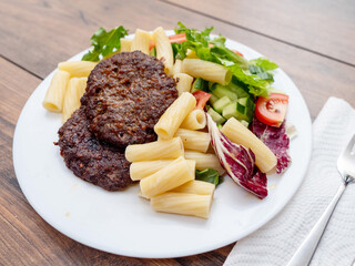 Meal with two tasty burgers, pasta and fresh salad and no sauce. Diet dinner for people with high blood sugar. Healthy food.