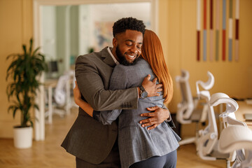 Confident businessman shares welcome embrace with teammate in office showing appreciation and...