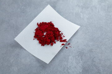 Powder of Allura Red AC, also known as FD&C Red 40. Food additive E129, azo dye commonly used in cosmetics, drugs, and food. Sample of controversial additive