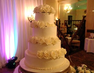Elegant five-tiered wedding cake adorned with white roses