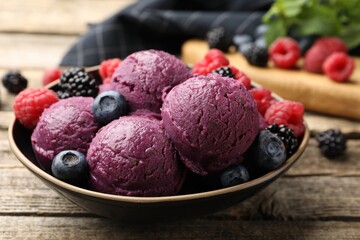 Delicious sorbet with fresh berries in bowl on wooden table, closeup