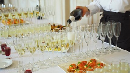 A trained professional is elegantly pouring champagne into glasses at a sophisticated gathering of guests. The Elegant Service of Champagne at a Luxurious and Memorable Event is Truly Unforgettable.