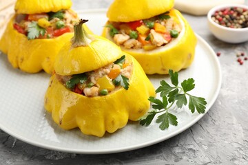 Tasty stuffed pattypan squashes on grey textured table, closeup