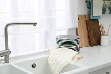 Clean dishware and waffle towel on countertop in kitchen