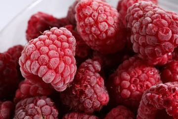 Many ripe frozen raspberries on light background, closeup