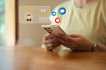 Asia woman using smartphone for select smiley face icon for client evaluation and customer satisfaction after use product and service concept...