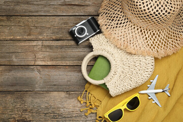 Time for summer vacation. Beach accessories, camera, toy plane and sunglasses on wooden background,...