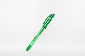 a green ballpoint pen against a plain white background