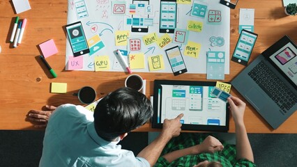 Top down view of manager working together to develop Ux Ui design for mobile interface. Developer...