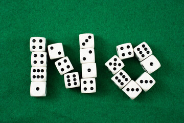 no to gambling, Dice are creatively arranged on a vibrant green surface to spell out the word No....
