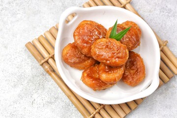 Kue Gemblong. Gemblong is made from white glutinous rice flour dough which is kneaded until smooth and shaped into a slightly flat oval and coated with sugar.