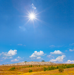 stony mountain ridge under a sparkle sun, mountain travel scene