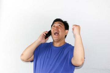 Fototapeta premium portrait of asian businessman talking on phone with winning gesture