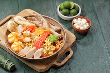 Seblak is a spicy culinary dish from West Java containing crackers, noodle, and chiscken feet with...