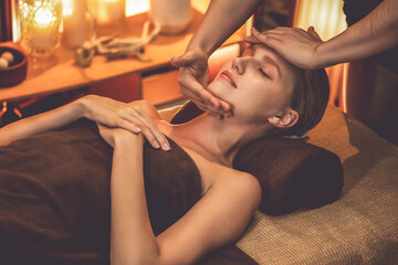 Caucasian woman enjoying relaxing anti-stress head massage and pampering facial beauty skin...