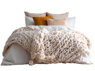 Cozy bed with a thick off-white chunky knit blanket and textured mustard and pink pillows.