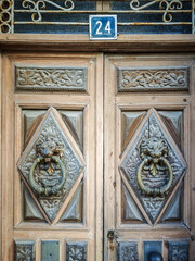 Ornate wooden door with lion-head knockers in Toro, Spain
