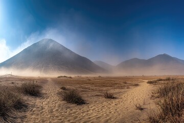 Dusty path winding through a dry landscape with a large mound in the distance.
