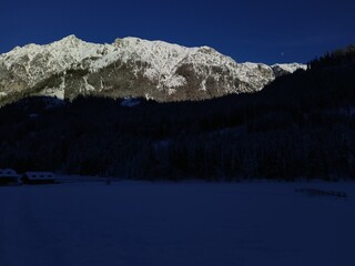 Snow-Capped Mountain Peaks with Dark Forest Shadows in Winter