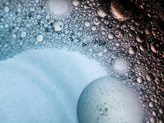 Abstract macro photo of bubbles forming in liquid with gradient lighting